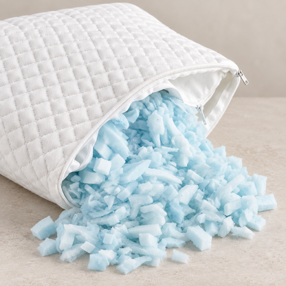 White quilted zippered pouch partly open to show pale blue-white shredded memory-foam pillow refill.
