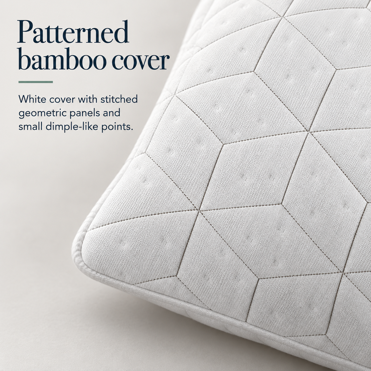 Close view of a white pillow corner showing rounded piping, stitched geometric panels and small dimple-like points on the cover.