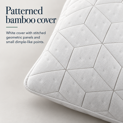 Close view of a white pillow corner showing rounded piping, stitched geometric panels and small dimple-like points on the cover.