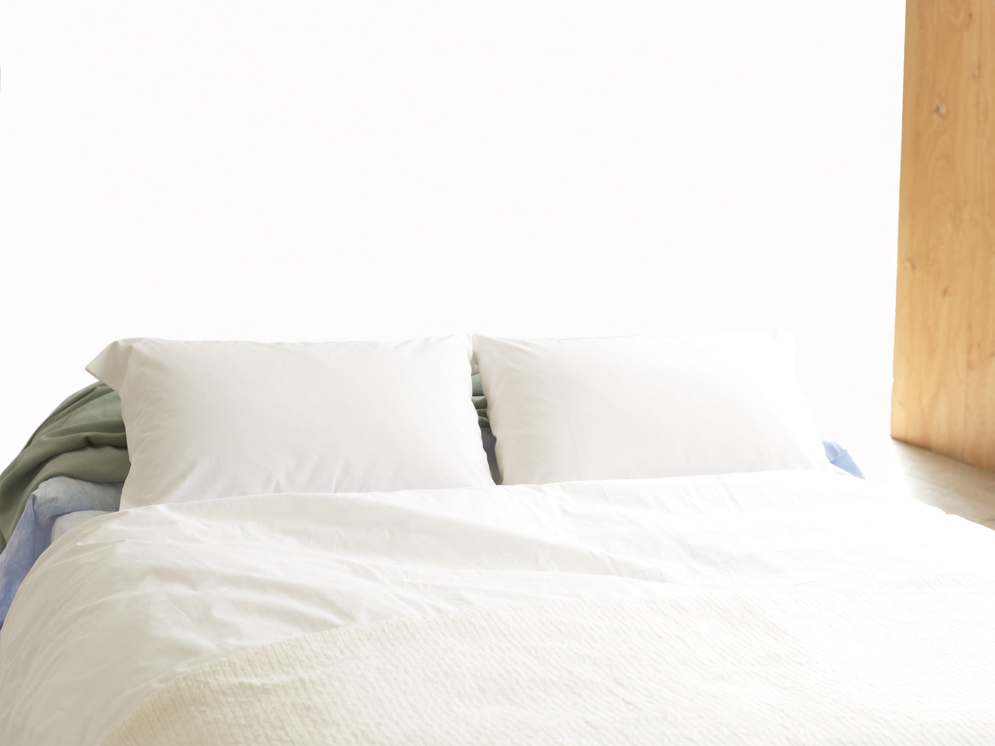 A softly lit bedroom with open air and neutral bedding